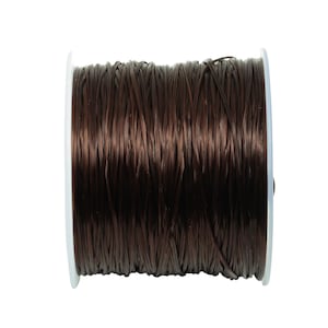 May include: A spool of brown elastic cord, wound tightly on a white plastic bobbin.