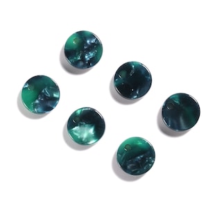 May include: Six round, teal and green marbled resin buttons with a hole in the center.