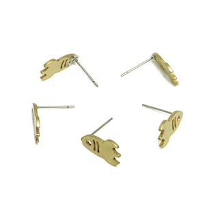 May include: Gold-colored rocket ship stud earrings. Each earring features a small, detailed rocket design with a silver post. The earrings are set against a white background, showcasing their shape and color.