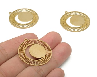 May include: Three gold-colored metal pendants. Each pendant features a circular design with a crescent moon shape inside a larger circle with radial lines. The pendants have a small loop at the top for attaching to a chain or other jewelry component.