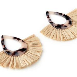 May include: A pair of dangle earrings with a tortoiseshell-patterned resin teardrop shape and a fringe of natural beige raffia.