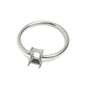 May include: A silver ring setting with a square bezel for a gemstone.