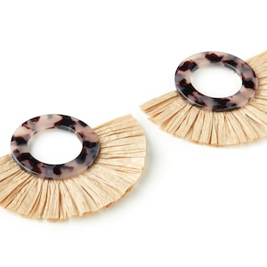 May include: A pair of earrings with a tortoiseshell-patterned circle pendant and a fringe of beige raffia.