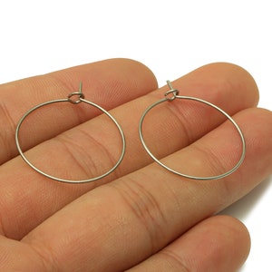 May include: A pair of silver hoop earrings. The earrings are simple and elegant, and they would be a great addition to any jewelry collection.