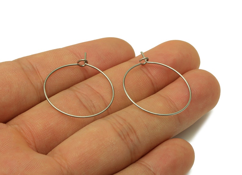 May include: A pair of silver hoop earrings. The earrings are simple and elegant, and they would be a great addition to any jewelry collection.