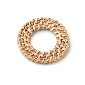 Puede incluir: Un posavasos redondo tejido de materiales naturales, de color marrón claro.