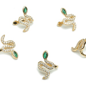 May include: Five gold snake ear cuffs with green gem accents and clear rhinestones.