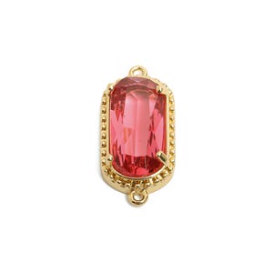 May include: A gold-toned pendant with a pink faceted glass stone in a rectangular shape. The pendant has a beaded border and a loop at the top for attaching to a chain.