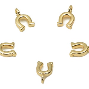 May include: Five gold-colored horseshoe charms with a loop at the top for attaching to jewelry or other crafts.