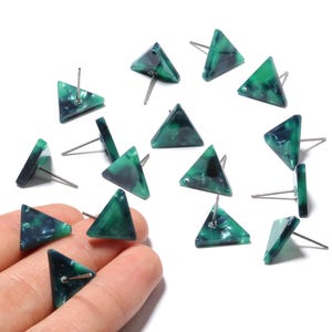 Puede incluir: Un conjunto de pendientes de botón triangulares. Los pendientes son de color verde y azul oscuro veteado. Los postes de los pendientes son plateados. Los pendientes se muestran sobre un fondo blanco.