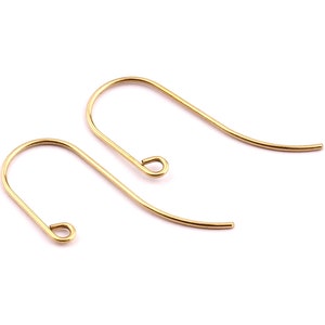 May include: Two gold-toned earring hooks, each with a small loop at the top. The hooks are made of metal and are designed to be used with earrings.