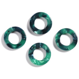 May include: Four green and blue marbled plastic rings with a hole in the center. The rings are about 1 inch in diameter.