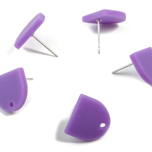 Puede incluir: Cinco pares de pendientes de botón morados. Los pendientes están hechos de un material liso y mate y tienen un diseño simple y moderno.