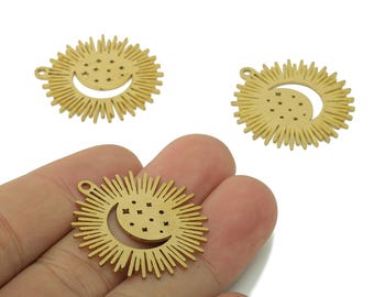 May include: Gold-colored metal charms featuring a sunburst design with a crescent moon and star details. The charms have a small loop for attaching to jewelry or other crafts. The celestial theme is prominent.