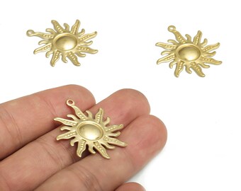 May include: Gold-colored sun-shaped charms with a loop for jewelry making. The sun charms have a detailed design with rays extending from a central circular face. One charm is held in a hand, and two others are on a white background.