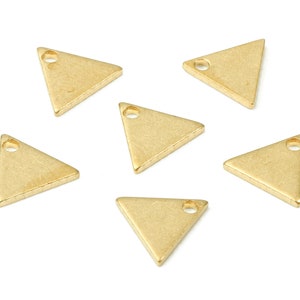 Peut inclure: Six breloques en forme de triangle dorés avec un petit trou en haut pour les attacher à des bijoux ou d'autres objets artisanaux.