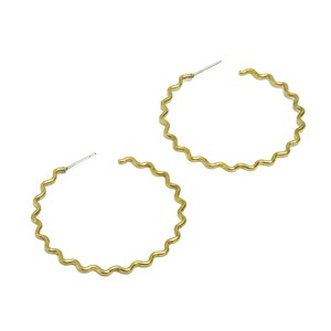 May include: A pair of gold-toned hoop earrings with a wavy, textured design.