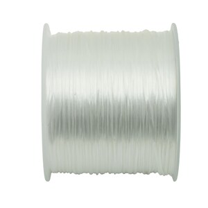 May include: A spool of white elastic cord, a type of string that stretches.