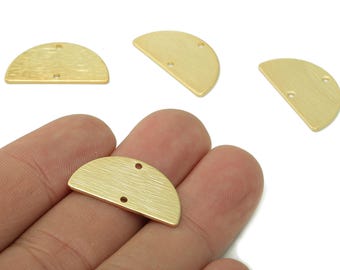 May include: Gold-colored, half-circle metal jewelry findings with a brushed texture. Each piece has two small holes for attaching to other components. One piece is held in a hand, with three others scattered nearby.