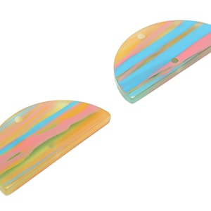 May include: Two half-circle shaped resin pieces with a marbled pattern in shades of yellow, pink, blue, and green. Each piece has two holes for hanging.