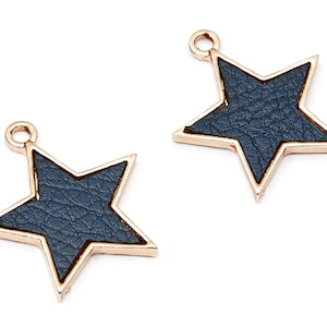 May include: Two gold-toned star-shaped charms with a blue faux leather center. The charms have a loop at the top for attaching to jewelry or other crafts.