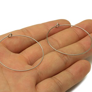 May include: A pair of silver hoop earrings. The earrings are simple and elegant, and they would be a great addition to any jewelry collection.
