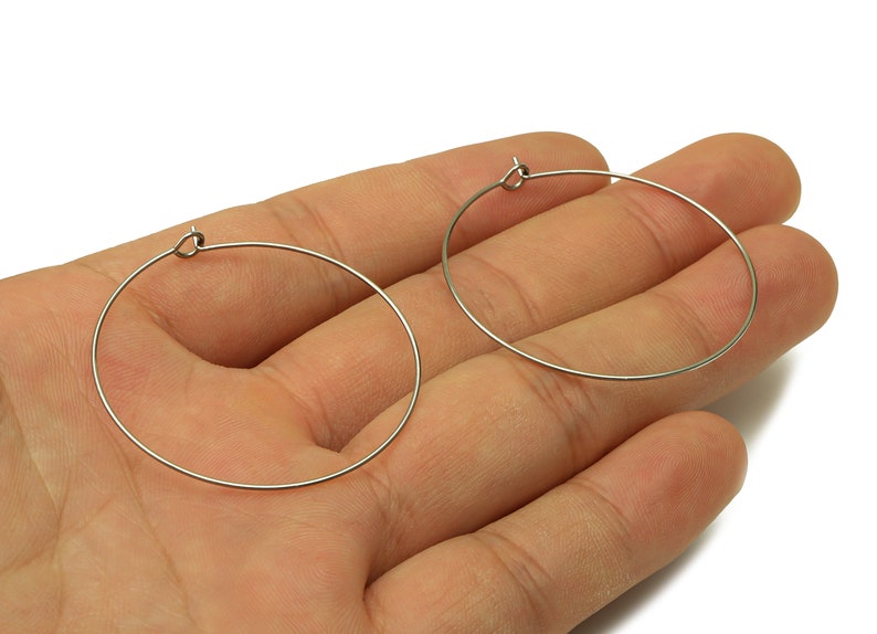 May include: A pair of silver hoop earrings. The earrings are simple and elegant, and they would be a great addition to any jewelry collection.