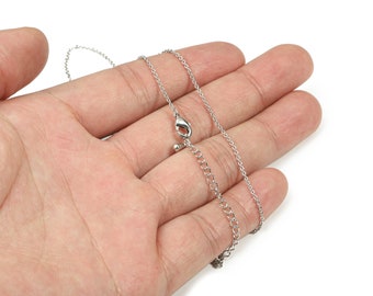 May include: A silver chain necklace with a lobster clasp closure.