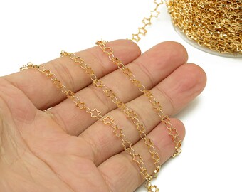 Op de afbeelding: Gouden sterketting, een close-up van de ketting in een hand, die het detail van de ster schakels laat zien.