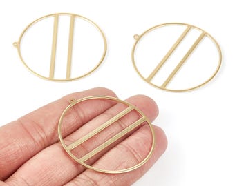 May include: Three gold-colored metal pendant charms. Two are circular with straight bars, and one is oval with straight bars. Each charm has a small loop for attaching to jewelry. The charms are shown against a white background.