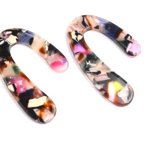 May include: A pair of colorful, abstract patterned, resin earrings in the shape of a large, rounded U.