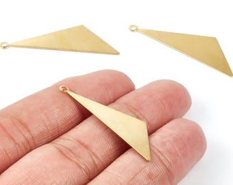 May include: Three gold-colored geometric charms with a triangular shape. One charm is held in a hand, while the other two are displayed separately. Each charm has a small loop at the top for attaching to jewelry.