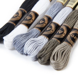 Puede incluir: Seis carretes de hilo de bordar en negro, blanco, gris, gris claro, marrón y beige. Los carretes están etiquetados con "Embroidery Thread" y "Alto".
