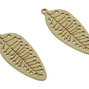 May include: Two gold-colored metal leaf-shaped charms with a delicate, intricate design. The leaves have a hole at the top for attaching to jewelry or other crafts.