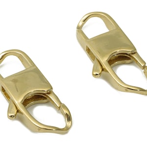 Puede incluir: Dos cierres de langosta de metal dorado, cada uno con una puerta de resorte y un bucle para sujetar a una cadena o correa.