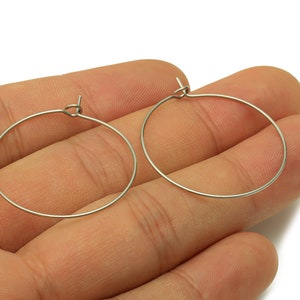 May include: A pair of silver hoop earrings. The earrings are simple and elegant, and they would be a great addition to any jewelry collection.
