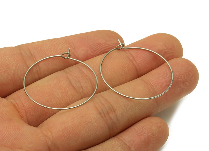 May include: A pair of silver hoop earrings. The earrings are simple and elegant, and they would be a great addition to any jewelry collection.