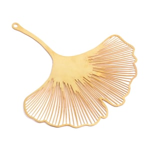 May include: A gold-colored metal ginkgo leaf bookmark with a delicate, intricate design.