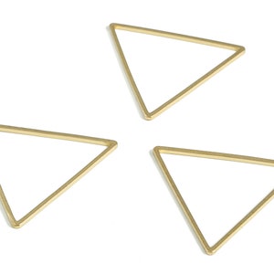 May include: Three gold-coloured metal triangle shapes.