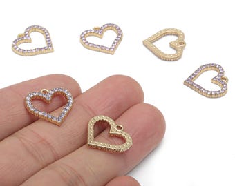 May include: Gold-colored heart-shaped charms with a small loop at the top for hanging. Some hearts are outlined with small, light purple rhinestones. The charms are likely for jewelry making or crafting.