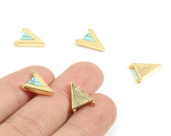 May include: Gold-colored triangle-shaped jewelry findings with a turquoise-colored inlay. The findings have a textured surface and small loops for attaching to other components. Several pieces are scattered on a white background.