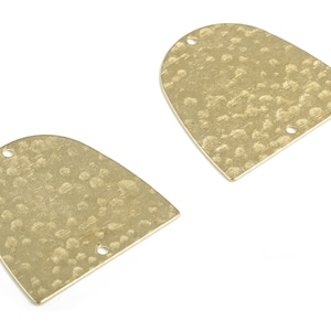 May include: Two gold-toned metal arch-shaped charms with a hammered texture and two holes each.