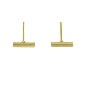 May include: A pair of gold bar stud earrings. The earrings are simple and minimalist, with a straight bar design.