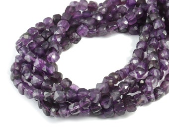 Può includere: Una collana di perle di ametista sfaccettate di colore viola scuro. Le perle sono infilate su un filo trasparente e sono disposte in un motivo sciolto e fluido.