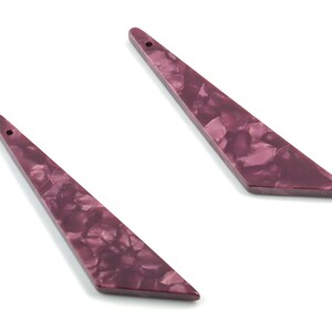 May include: Two long, pointed, purple, marbled, plastic earrings.