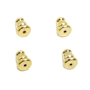 May include: Four gold-colored metal finials with a rounded, bulbous shape. Each finial has three tiers and a small hole in the center.