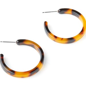May include: A pair of brown and black tortoise shell hoop earrings. The earrings are made of a thick, durable plastic and have a smooth, polished finish.