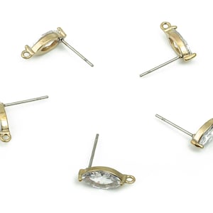 May include: Four gold-tone earring settings with clear marquise-shaped stones and posts.
