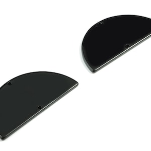 Puede incluir: Dos formas metálicas negras en forma de semicírculo con agujeros en la parte superior e inferior. Las formas son lisas y brillantes.