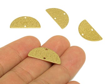 May include: Close-up of several gold-colored, half-moon shaped metal jewelry findings. Each piece has a textured surface and two small holes for attaching to other components. The findings are shown against a white background.
